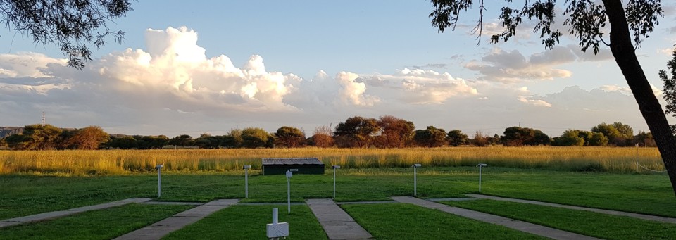 Kimberley shooting range at sunset with green lawns and dramatic clouds